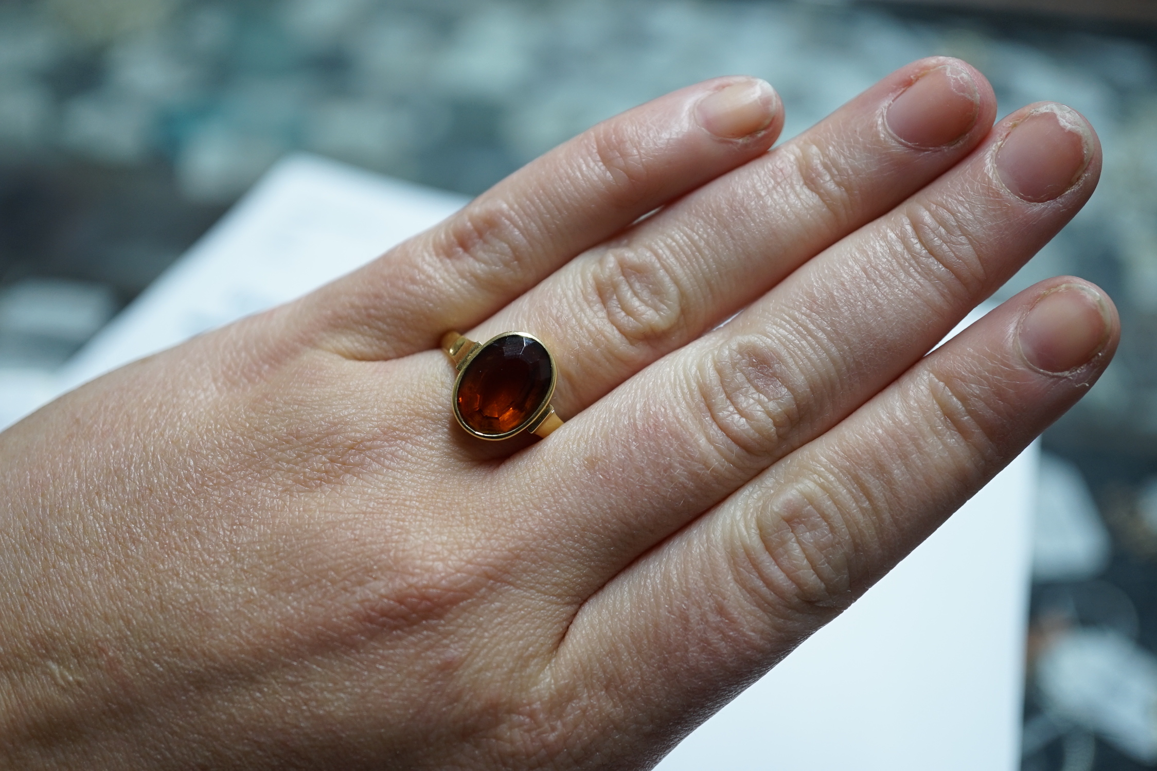 A George V 750 yellow metal and oval cut citrine set ring, size Q, gross weight 5.6 grams.
